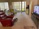 Spacious living room with large windows, mirrored wall, and sliding door access to the balcony at 1370 Heather Ridge Blvd # 310, Dunedin, FL 34698
