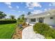 Inviting front entrance with brick walkway, manicured garden, and a cheerful blue door, creating a warm welcome at 1391 50Th Ne Ave, St Petersburg, FL 33703
