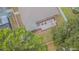 Aerial view of landscaped backyard with a patio and surrounded by mature trees at 1418 Rushgrove Cir, Dover, FL 33527