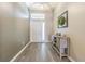 Front foyer featuring a decorative cabinet, wreath and wood-look floors at 1418 Rushgrove Cir, Dover, FL 33527