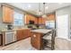 Well-lit kitchen boasts stainless appliances, granite counters, an island, and wood-look flooring at 1418 Rushgrove Cir, Dover, FL 33527