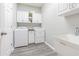 Bright laundry room with appliances, sink and white cabinets at 1418 Rushgrove Cir, Dover, FL 33527