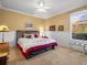 Bedroom with tan carpet and white and red bedding at 15254 Bellamy Rd, Tampa, FL 33625