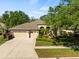 Charming beige house with a three-car garage and lush landscaping enhancing its curb appeal at 15254 Bellamy Rd, Tampa, FL 33625