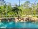 Beautiful backyard pool with water feature and forest views through screen at 15254 Bellamy Rd, Tampa, FL 33625