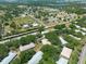 An aerial view of homes nestled among mature trees, with roads leading to commercial areas and community amenities at 1616 Laughton Pl, Sun City Center, FL 33573