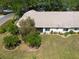 Aerial view showcasing a well-maintained yard, lush landscaping, and a charming house with a neatly kept exterior at 1616 Laughton Pl, Sun City Center, FL 33573