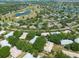 Aerial view of a residential neighborhood showcasing homes surrounded by lush greenery and a scenic lake for recreational enjoyment at 1616 Laughton Pl, Sun City Center, FL 33573
