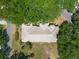This aerial shot reveals a home with a well-maintained roof, surrounded by mature trees, shrubbery, and green lawns at 1616 Laughton Pl, Sun City Center, FL 33573
