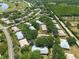 An aerial view shows a neighborhood with lush green trees and well-maintained landscaping, next to a golf course and lake at 1616 Laughton Pl, Sun City Center, FL 33573