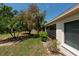Lush backyard featuring tropical landscaping, a lawn, and a view of the screened-in lanai at 1616 Laughton Pl, Sun City Center, FL 33573