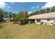 View of backyard featuring mature trees, a lush lawn, and an enclosed sunroom at 1616 Laughton Pl, Sun City Center, FL 33573