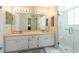 A bathroom features double sinks, a vanity, a mirror, and a glass enclosed shower at 1616 Laughton Pl, Sun City Center, FL 33573