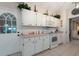 Kitchen featuring white cabinets and appliances, tile floor, pink countertops, and exterior door at 1616 Laughton Pl, Sun City Center, FL 33573