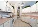 A kitchen features white appliances, cabinets, tile flooring, and pink countertops at 1616 Laughton Pl, Sun City Center, FL 33573