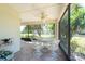 Screened-in lanai with a dining set and a beautiful view of the lush greenery at 1616 Laughton Pl, Sun City Center, FL 33573