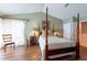 A main bedroom features a four-poster bed, wood flooring, and neutral decor at 1616 Laughton Pl, Sun City Center, FL 33573