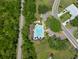 An aerial view shows a sparkling community pool surrounded by lush greenery and shaded lounge areas at 1616 Laughton Pl, Sun City Center, FL 33573