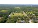 Aerial view showcasing expansive property with lush greenery, mature trees, a pond, and well-maintained grounds at 1691 Ridge Top Dr, Tarpon Springs, FL 34688