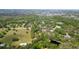 Aerial view of a large property with lush greenery, mature trees, a pond and outbuildings at 1691 Ridge Top Dr, Tarpon Springs, FL 34688
