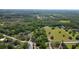 An aerial view of the property, highlighting the ample land, mature trees, and additional structures at 1691 Ridge Top Dr, Tarpon Springs, FL 34688