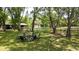 Relaxing backyard under mature trees offers tranquil seating area and fire pit at 1691 Ridge Top Dr, Tarpon Springs, FL 34688