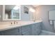 Beautiful bathroom featuring a double sink vanity with grey cabinets and white quartz countertops at 1691 Ridge Top Dr, Tarpon Springs, FL 34688