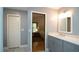 Bathroom featuring double sinks, quartz countertops, and a closet view to a bedroom at 1691 Ridge Top Dr, Tarpon Springs, FL 34688