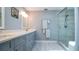 Bathroom featuring double sinks, quartz countertops, and a glass door shower at 1691 Ridge Top Dr, Tarpon Springs, FL 34688