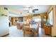 Well-lit dining area with wooden table, tile floors, and views into the kitchen and an additional living area at 1691 Ridge Top Dr, Tarpon Springs, FL 34688