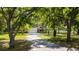 Beautiful exterior view of home showing the driveway leading up to the garage surrounded by mature trees at 1691 Ridge Top Dr, Tarpon Springs, FL 34688