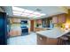 Bright kitchen with white tile floors, wooden cabinets, and a large skylight at 1691 Ridge Top Dr, Tarpon Springs, FL 34688