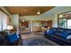 Cozy living room with wood ceilings, tile floors, and multiple seating areas at 1691 Ridge Top Dr, Tarpon Springs, FL 34688