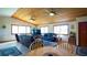 Spacious living room with wood ceilings, tile floors, leather seating and an entertainment center at 1691 Ridge Top Dr, Tarpon Springs, FL 34688