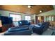 Inviting living room featuring wood ceilings, tile floors, leather seating and large windows at 1691 Ridge Top Dr, Tarpon Springs, FL 34688