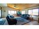 Comfortable living room with wood ceilings, large windows, tile floors and leather seating at 1691 Ridge Top Dr, Tarpon Springs, FL 34688
