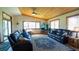 Bright living room with wood ceiling, tile floors, leather furniture and large windows at 1691 Ridge Top Dr, Tarpon Springs, FL 34688