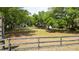Expansive pasture with mature trees and wooden fencing offers privacy and a serene setting at 1691 Ridge Top Dr, Tarpon Springs, FL 34688
