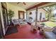 Covered porch with wicker furniture, decorative plants, and serene outdoor views at 1691 Ridge Top Dr, Tarpon Springs, FL 34688