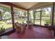 Screened-in porch with views of the backyard, seating and lush greenery at 1691 Ridge Top Dr, Tarpon Springs, FL 34688