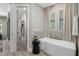 Modern bathroom with a freestanding tub, tiled walls, and natural light from a window at 17320 Nokota Ave, Hudson, FL 34667