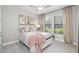 Cozy bedroom featuring a ceiling fan, neutral colors, artwork, and windows for natural light at 17320 Nokota Ave, Hudson, FL 34667