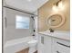 Updated bathroom featuring a tub with shower and a stylish white vanity with a marble countertop at 208 Ne Lincoln N Cir, St Petersburg, FL 33702