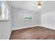 Bedroom with wood floors, ceiling fan, large window, and a built-in closet at 208 Ne Lincoln N Cir, St Petersburg, FL 33702