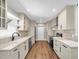 Bright kitchen features updated cabinets, countertops, modern appliances, and stylish hardwood floors at 208 Ne Lincoln N Cir, St Petersburg, FL 33702