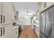 Bright kitchen featuring stainless appliances, hardwood floors, white cabinetry and tile backsplash at 208 Ne Lincoln N Cir, St Petersburg, FL 33702