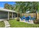 Backyard with Adirondack chairs around a concrete pad, wooden fence, and a detached building at 2215 Thrace St, Tampa, FL 33605