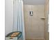Bathroom tiled shower features shower curtain, tiled walls, and mounted soap dispenser at 2215 Thrace St, Tampa, FL 33605