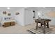White-walled bedroom with a queen bed, a foosball table, in-unit laundry, and light wood floors at 2215 Thrace St, Tampa, FL 33605