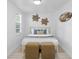 Bedroom with a white-painted wood slat accent wall, window, wicker ottomans, and queen bed at 2215 Thrace St, Tampa, FL 33605